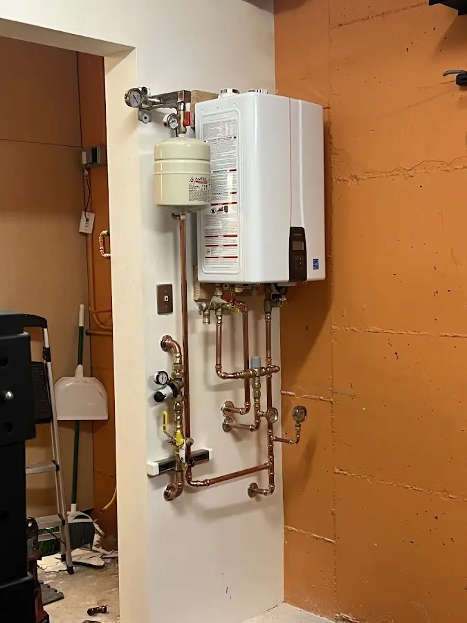 Plumbing technician inspecting water heater connections in DuBois